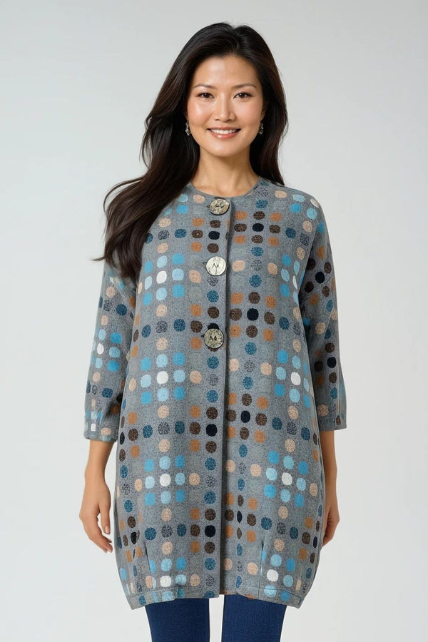 Woman wearing a patterned Chalet coat and blue leggings on a white background